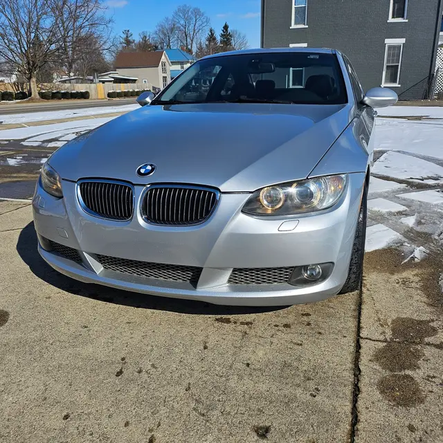 Silver coupe parked outside, seen from the front