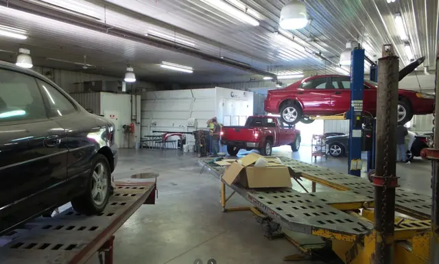 Inside the shop: cars on a frame straightening bench and a lift